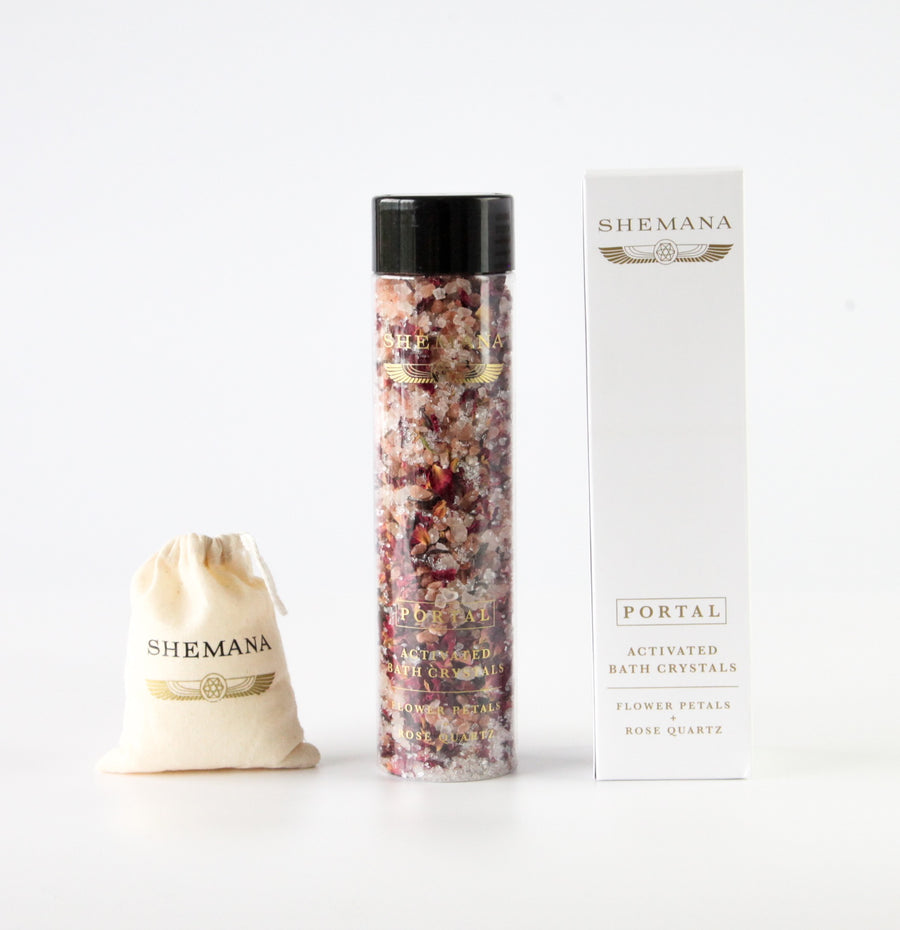 white box, shemana logo, tall plastic bottle filled with pink bath salts and wildflowers, black  lid, shemana cotton small bag
